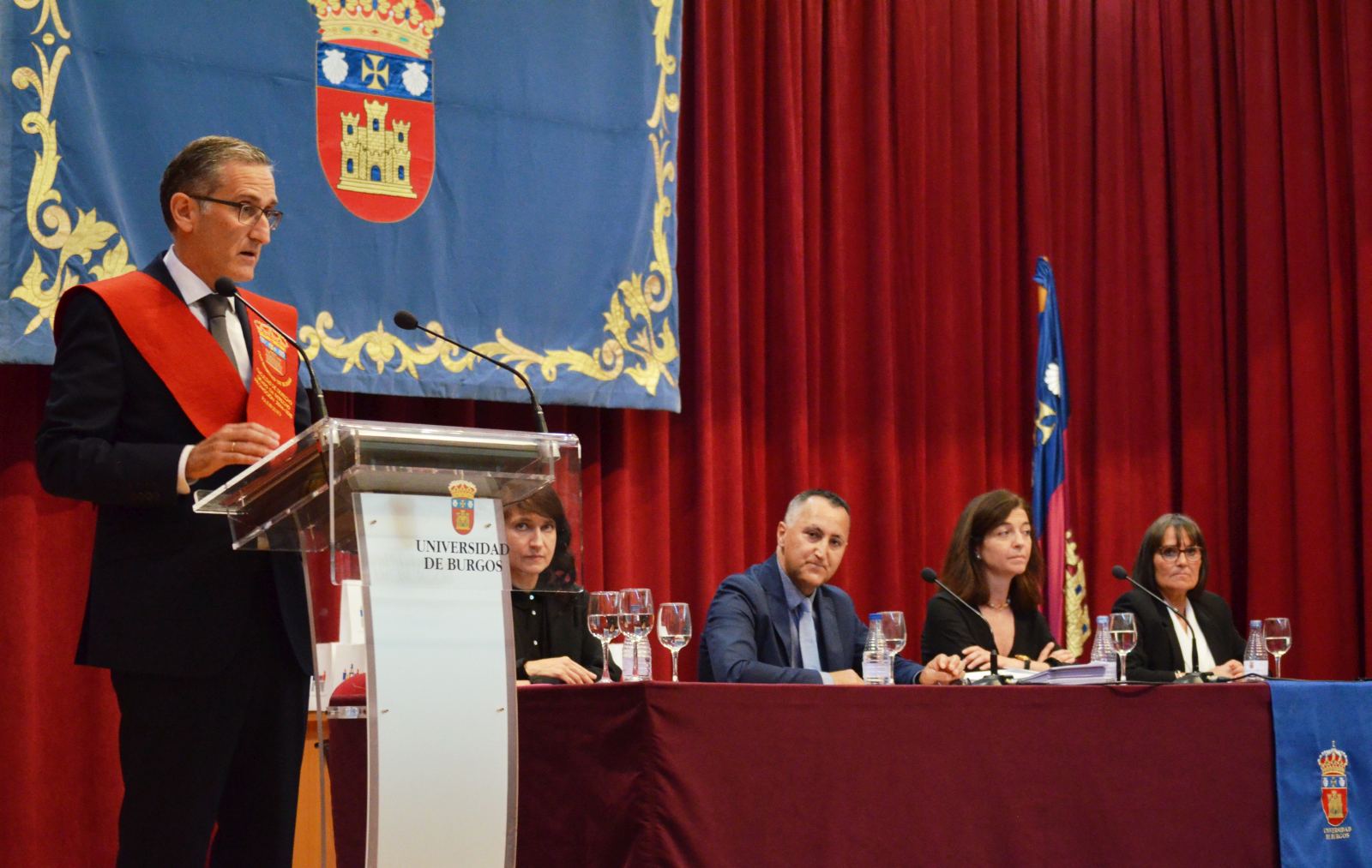 el padrino leyendo el discurso y la mesa presidencial