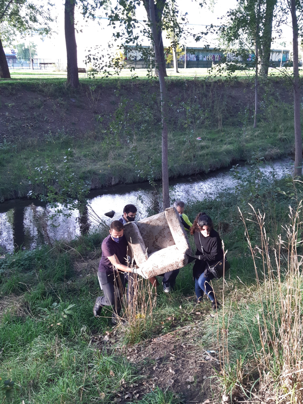 Voluntariado ambiental 08-10-2020 Foto de personas sacando un sofá de la orilla del río