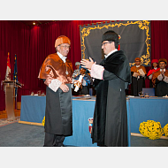 Entrega de atributos. El rector le impone la medalla y le entrega el diploma.