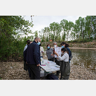 Grupo de personas al lado de un río analizando muestras